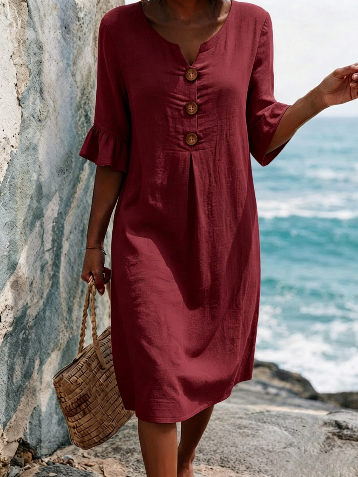 Einfarbiges Baumwollkleid mit V-Ausschnitt, drei Holzknöpfen, vorderen Falten und schmeichelhaften, gerafften, mittellangen Ärmeln.
