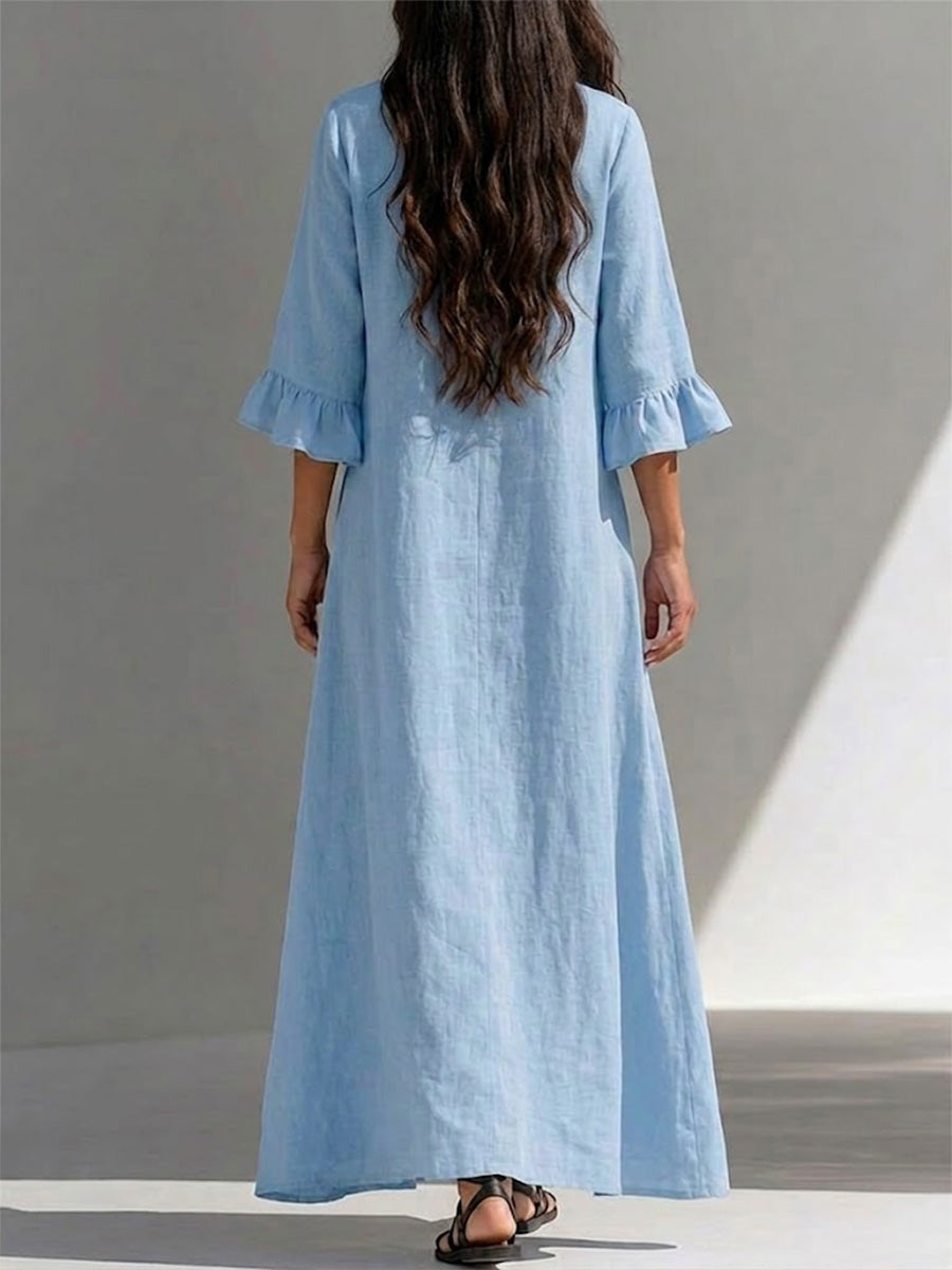 Vestido largo con cierre parcial de botones, detalles fruncidos, mangas tres cuartos con volantes y un ajuste favorecedor que disimula la figura.