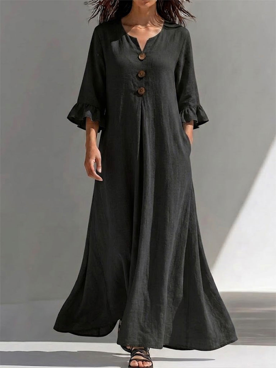 Vestido largo con cierre parcial de botones, detalles fruncidos, mangas tres cuartos con volantes y un ajuste favorecedor que disimula la figura.