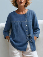 Waschbare Denim-Bluse mit rundem Ausschnitt, diagonaler Knopfleiste, geraffter Brustpartie, seitlicher Schleife, 3/4-Ärmeln und lockerem, lässigem Schnitt