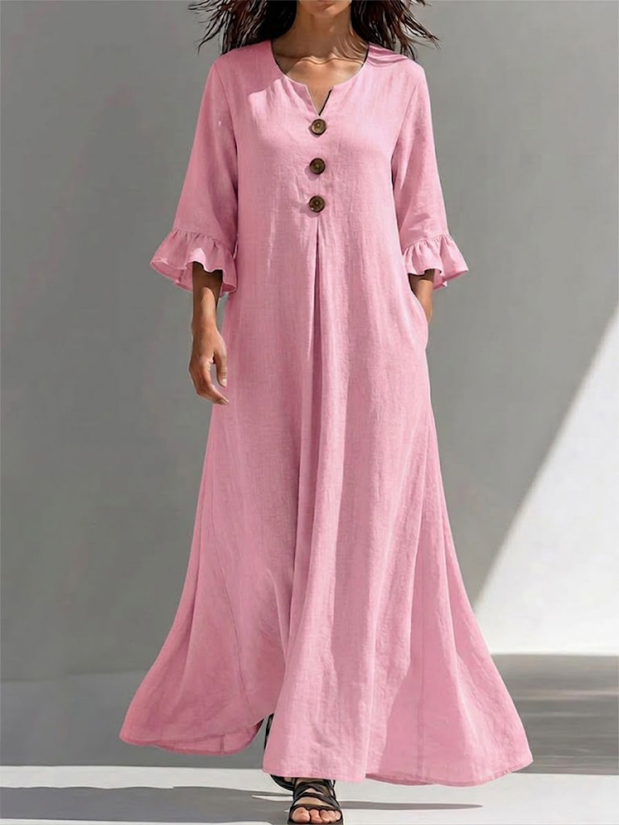 Vestido largo con cierre parcial de botones, detalles fruncidos, mangas tres cuartos con volantes y un ajuste favorecedor que disimula la figura.