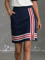 Completo sportivo da donna composto da top a maniche corte a righe con mezza cerniera e gonna con tasche