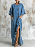 Vestito in denim lavato alla caviglia con scollo rotondo, spalle scese, maniche larghe a gomito, spacchi laterali e grandi tasche applicate, dalla vestibilità ampia.