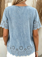 Damebluse i lysvasket denim med blomstrete øyehull, bølget kant, korte ermer og lommer