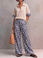 Dames tweedelig set met een casual, losvallend, kort mouwig pullover topje met kraag en een hoge taille, losvallende, wijde broek met luipaardprint.