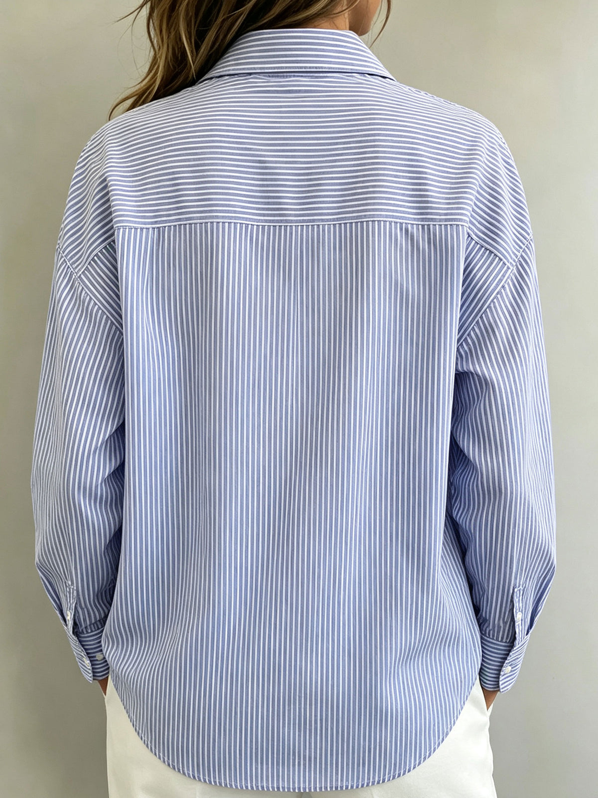 Camicia da donna a righe, tessuta, con scollo a collo, maniche lunghe, bottoni sul davanti e ritagli.